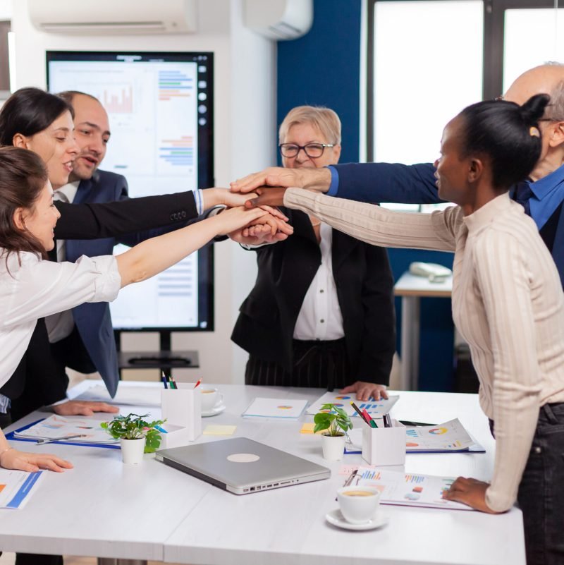 Cheerful overjoyed business people in conference room celerating Diverse colleagues with new opportunity enjoing victory meeting in broadroom office.